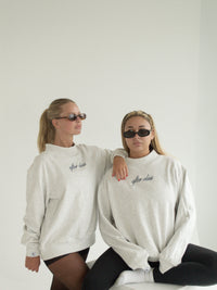 Two models wearing the heather-grey After Class mockneck sweatshirt with sunglasses