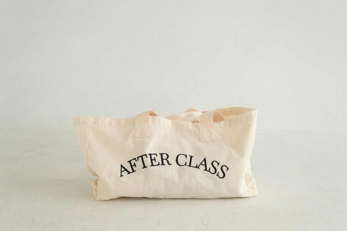 The After Class natural cotton-canvas tote, front view with 'AFTER CLASS' in black serif type
